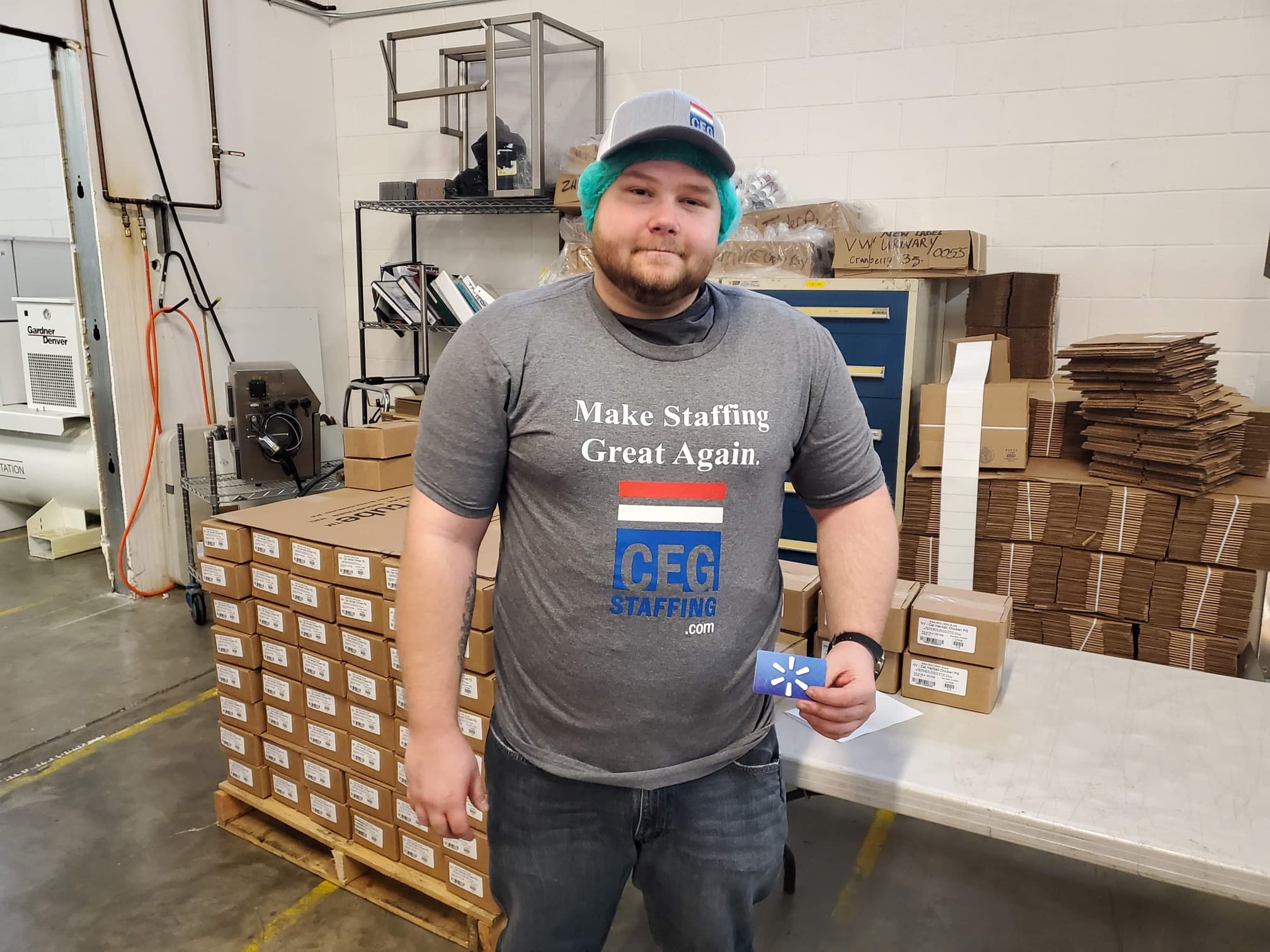 A man wearing a red shirt with the slogan "Make Staffing Great Again" printed in white letters.
